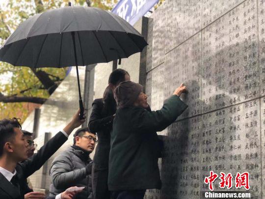 夏淑琴老人用手撫摸著親人的名字?！≈鞎苑f 攝